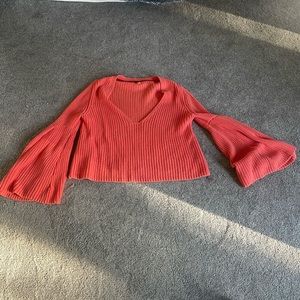 Free People Coral Sweater with wide sleeves.
